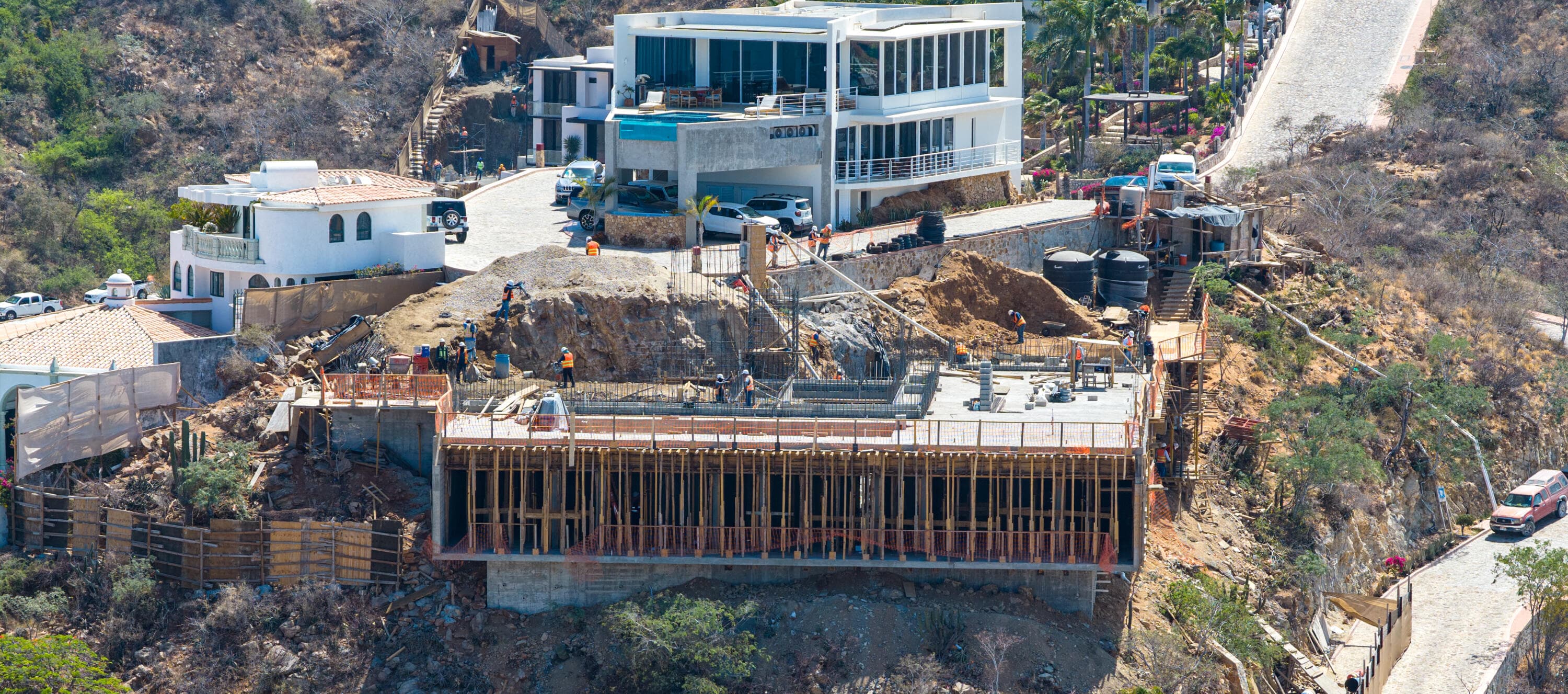 Crew tying rebar on the Villa del León cliffside structure in Pedregal, Cabo